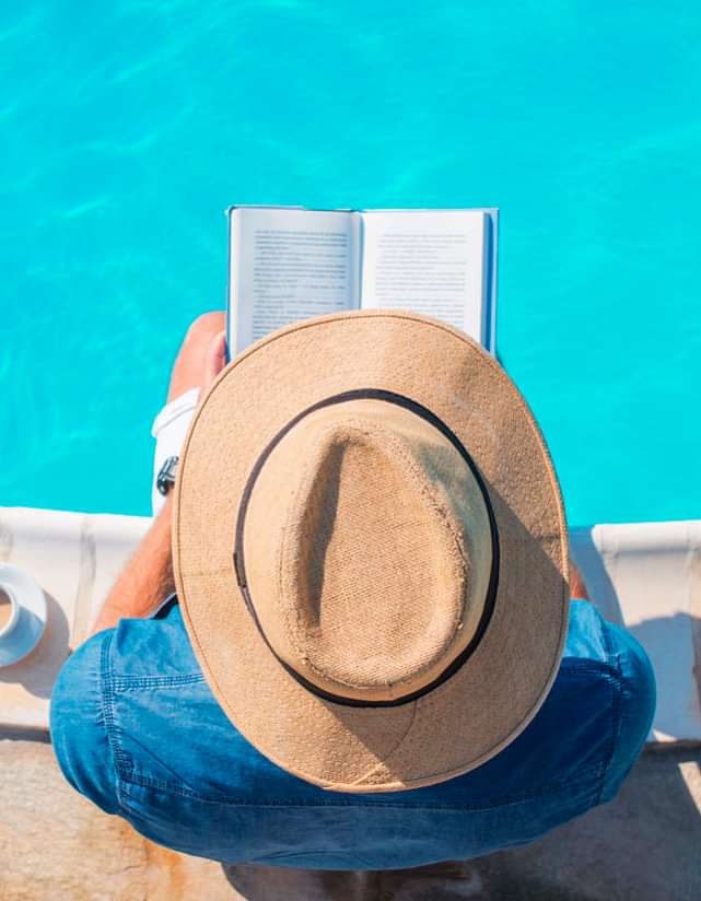 guy reading a book by the pool