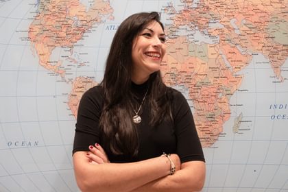 Carmen Muñoz-Fernández in front. of a world map