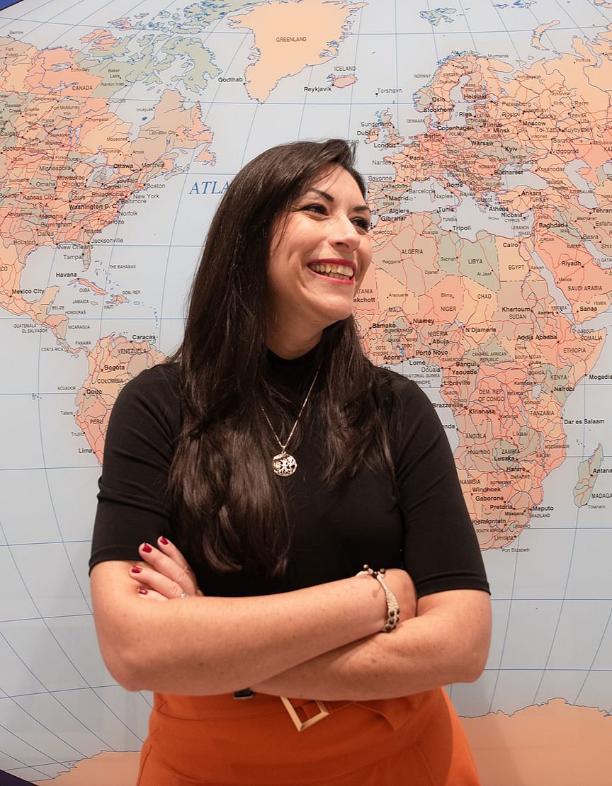 Carmen Muñoz-Fernández in front. of a world map