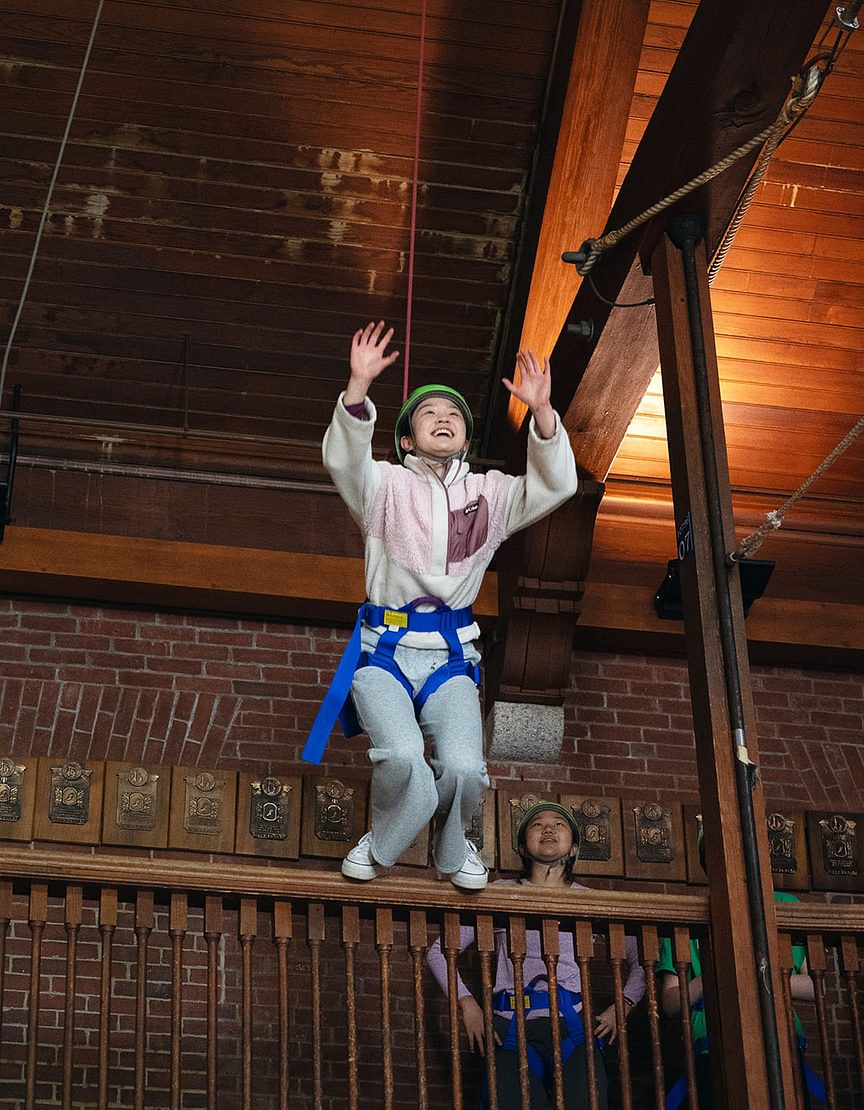Student smiling while exploring the ropes course